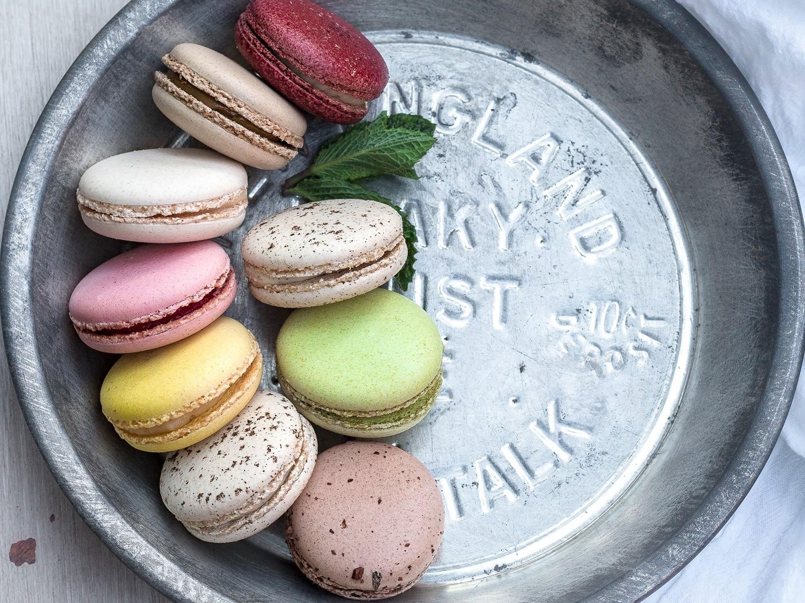Assorted French Buttercream Macarons in pastel colours on a vintage silver tray, highlighting dessert presentation for baking enthusiasts.